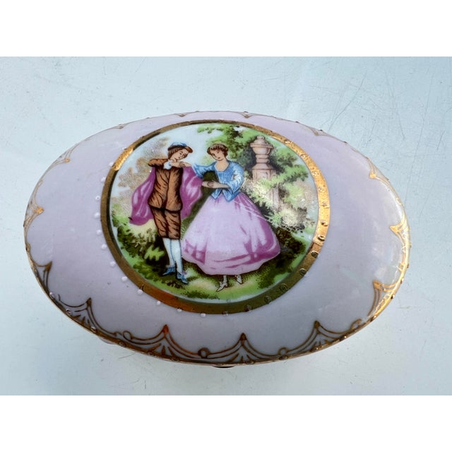 Vintage Porcelain Footed/Hinged Lid Trinket Box. Handpainted with a scene of a Courting Couple on the lid. Porcelain...
