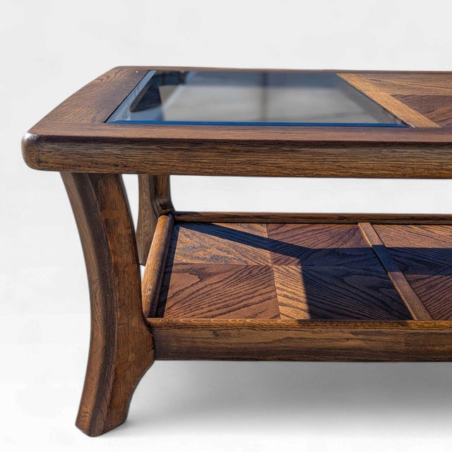 A substantial late 20th-century coffee table crafted from oak with a deep, expressive grain and architectural smoked glass...