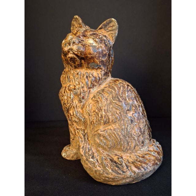 Exhibiting exceptional sculptural presence, this antique cast iron doorstop captures a seated fluffy cat rendered with...