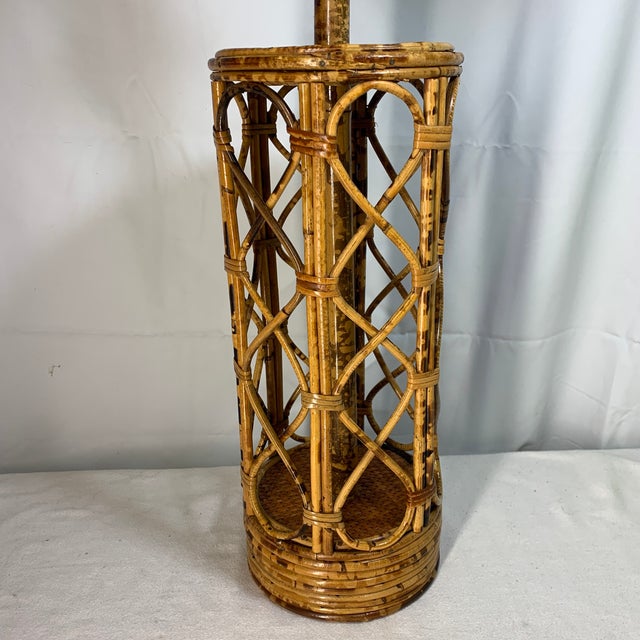 This vintage mid-century cylindrical table lamp features an open architectural lattice design crafted from hand-wrapped...