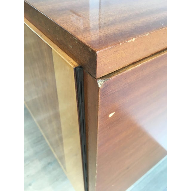 This very nice sideboard is made of Sapelli mahogany and sicamore wood on a black lacquered wood base with brass elements....