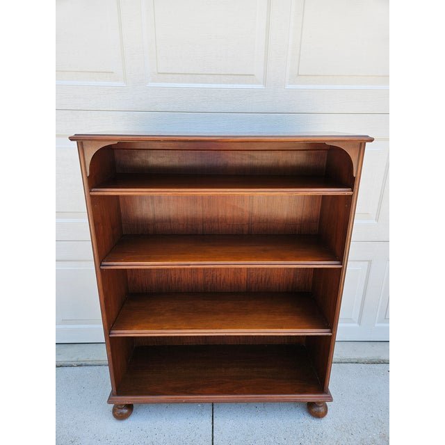 This Imperial Furniture mahogany bookcase has three adjustable shelves and sits atop bun feet. The bookcase is three feet...