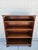 This Imperial Furniture mahogany bookcase has three adjustable shelves and sits atop bun feet. The bookcase is three feet...