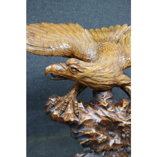 Hand carved walnut eagle sculpture with outstretched wings mounted on a carved burl wood base. Detailed carving throughout...