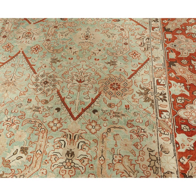 Hand-knotted of high-quality wool in accordance with centuries-old techniques circa 1920, this antique Tabriz rug is an...