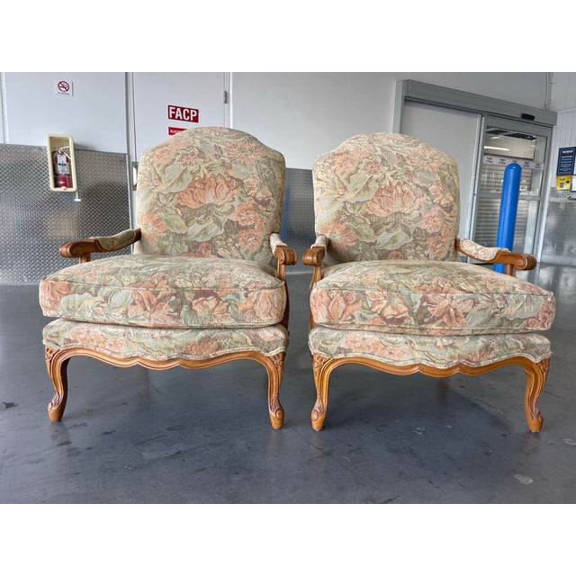 Pair of French-style bergère armchairs by Century Furniture with nicely carved wood frames and a warm, even finish....
