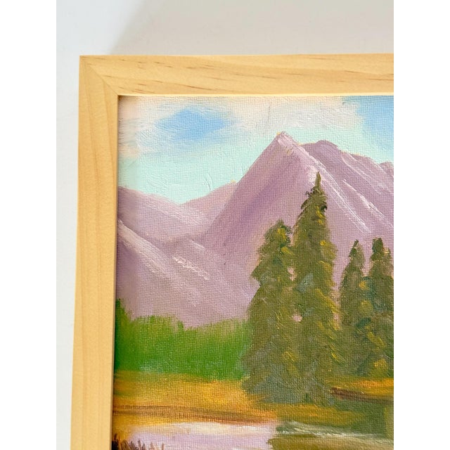 Vibrant acrylic landscape painting on canvas, depicting a flowing river at the base of majestic mountains and pines. A...