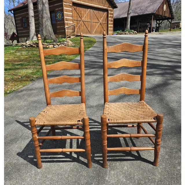 A lovely pair of antique Shaker-style ladder-back chairs with woven or splint seats, likely dating from the late 19th to...