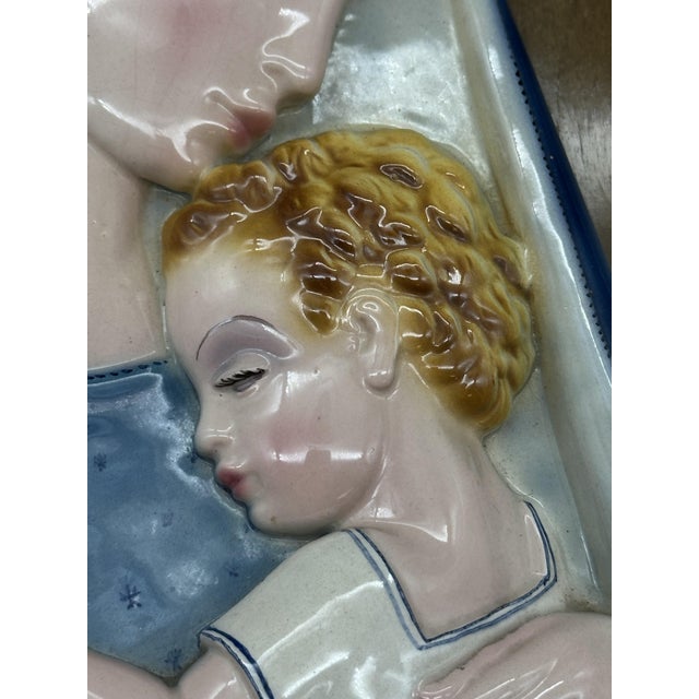 Madonna and Child, created by Tosin Tarcisio in 1930. Hand-painted ceramic, mounted on a wooden panel, with a metal halo...
