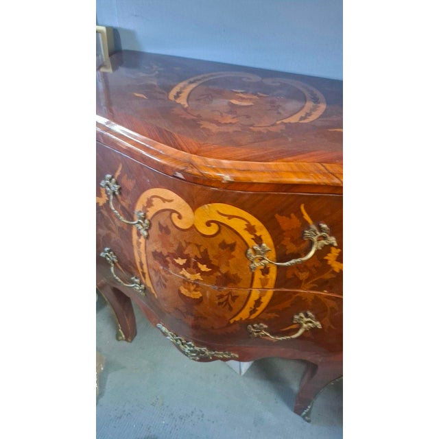 Small Louis XV style marquetry chest of drawers. This chest rests on two drawers. Made in the 1970s. The drawer interiors...