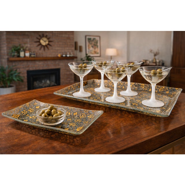 A striking set of three vintage Georges Briard glass platters featuring a bold metallic gold geometric and botanical...