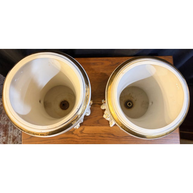 An exceptional and highly decorative pair of antique Edwardian-era Campana-style twin-handled porcelain garniture urns....