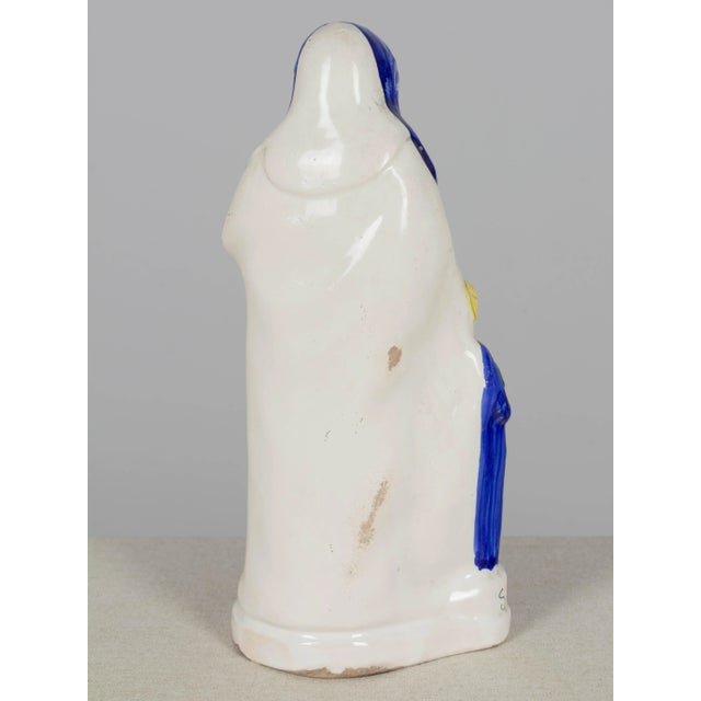 A Henriot Quimper French faience statue of Saint Anne and the young Virgin Mary. Polychrome enameled earthenware, hand-...