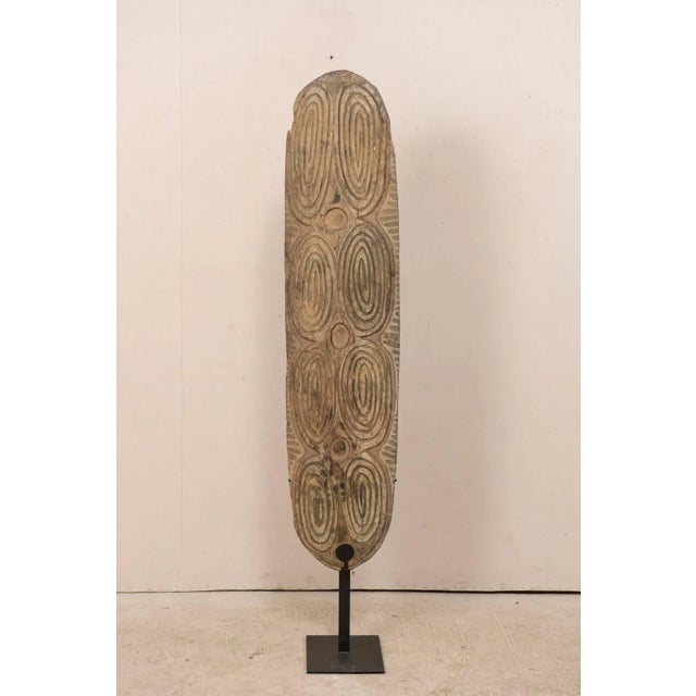 A carved wood war shield from the Ambunti mountain region, along the upper Sepik river in Papua New Guinea. This hand-...
