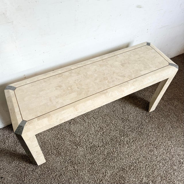 Postmodern elegance meets coastal charm in this polished tessellated stone and shell console table. With a sleek brass...