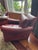 Late 20th Century made in USA. Substantial burgundy leather club chairs with brass nailhead trim, wooden bun feet and...