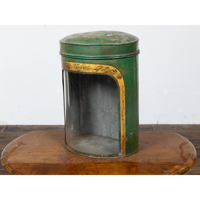 An English Parnall & Son green painted metal tea box from the 19th century with gilt painted floral frieze, glass front...
