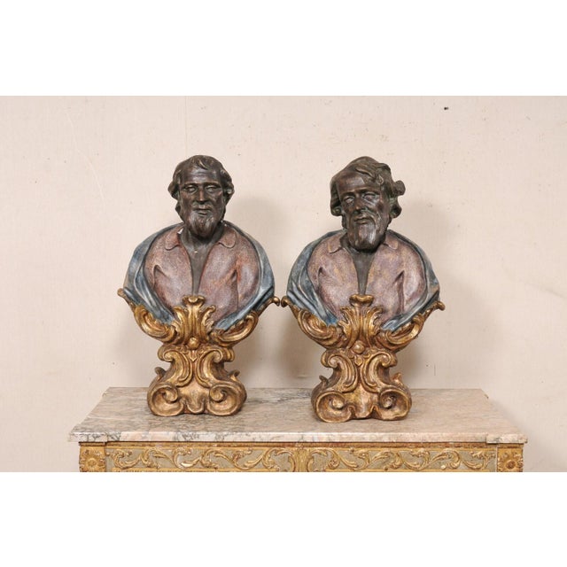 An Italian pair of hand-painted paper mâché male busts. These vintage art decorations from Italy have been artfully...