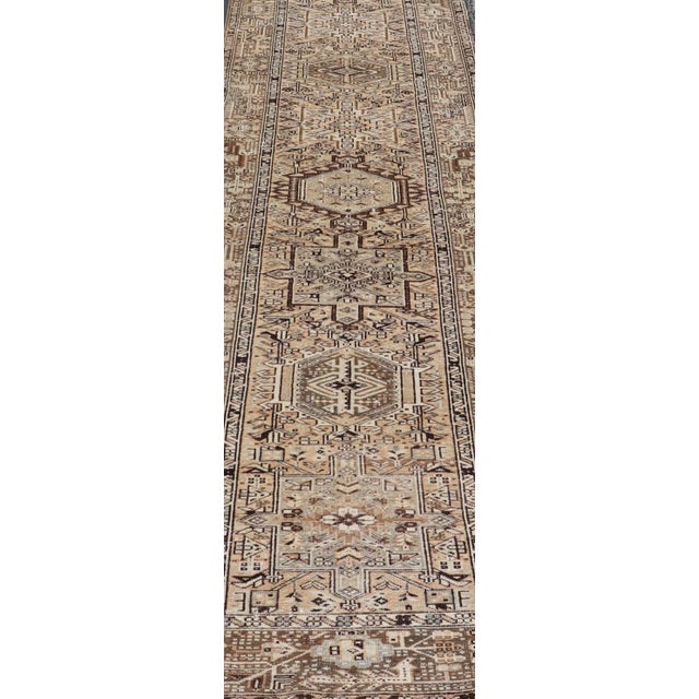 This vintage 1940's Karadjeh features brown and sandy tones and majestic medallions within the field. The wide banded...