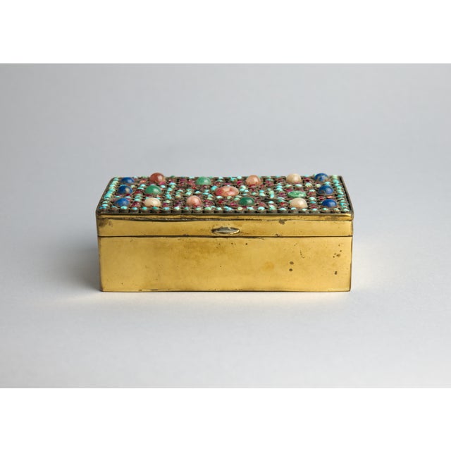 A densely jeweled Nepalese brass jewelry box with a lid set entirely in hand-inlaid semi-precious stones: turquoise, lapis...