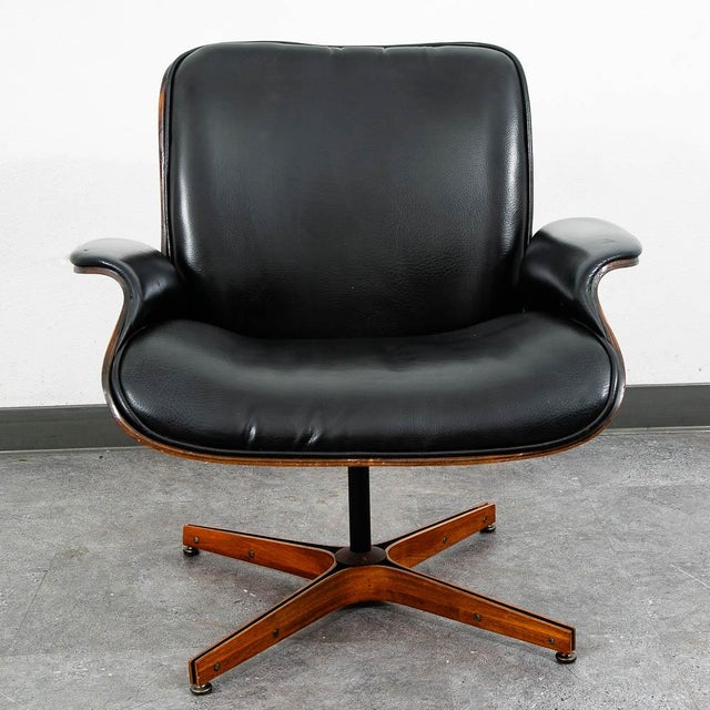 Molded plywood lounge chair by George Mulhauser. This chair features a unique low-profile design, black upholstery, and a...
