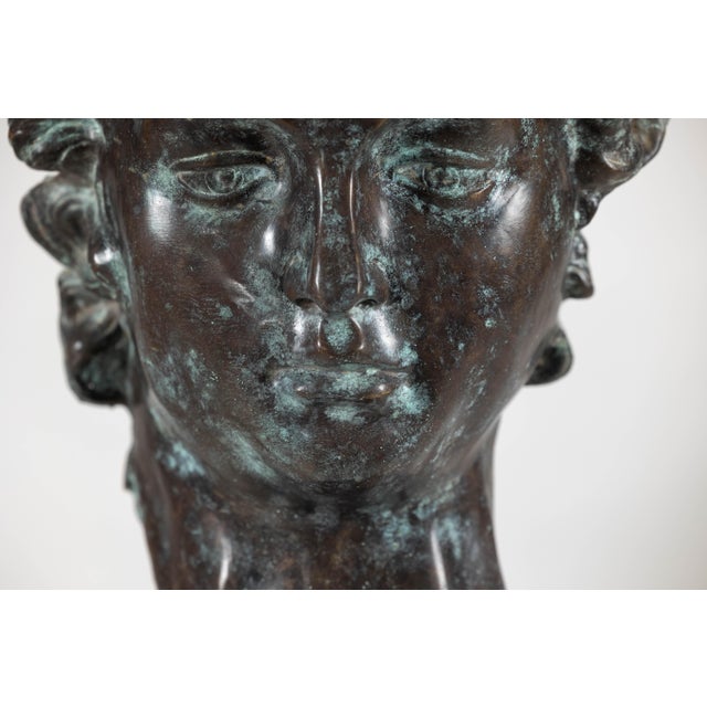 A bronze sculpture depicting David's head mounted on a custom base. This contemporary bronze head sculpture pays homage to...