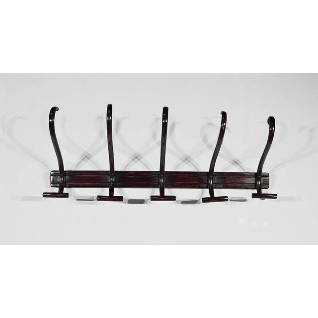 Coatwork (and flag holder (and flag holder) Thonet stamped. This cloakroom in beech in a very deep mahogany tone has 5...