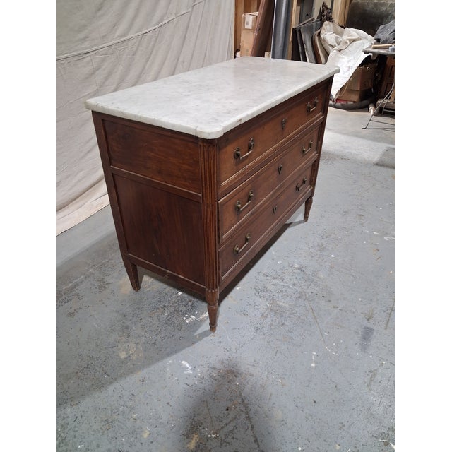 A handsome late 18th-century French Louis XVI period commode crafted in richly figured walnut and crowned with its...