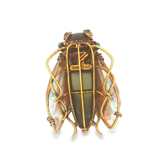 This beetle brooch by Iradj Moini is crafted in brass with gold plating. The piece features a black onyx body with abalone...