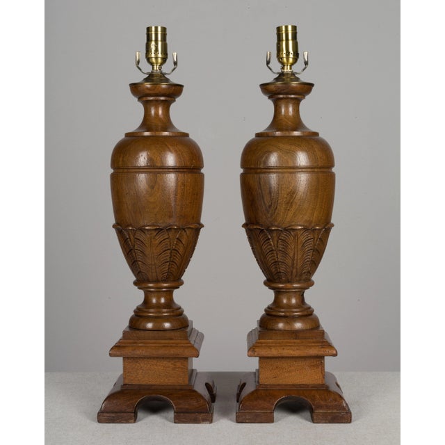 A pair of 19th Century French baluster form table lamps made of solid turned walnut with carved decorative details. Made...