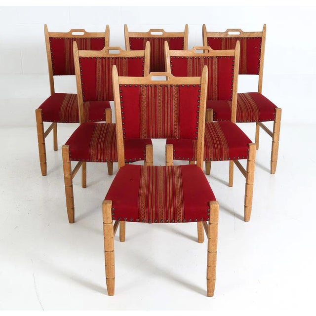 A set of 6 classic Danish modern dining chairs upholstered in a cheeky red striped fabric offset by densely grained carved...