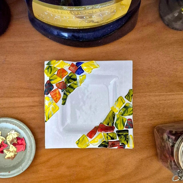 A small but intentional statement piece, this square art glass tray features a smooth white glass base accented with kiln-...