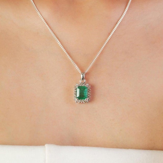 Featuring a 7×9 mm octagon-cut emerald gemstone weighing 9.3 carats, accented with diamonds totaling 1.9 carats, this...