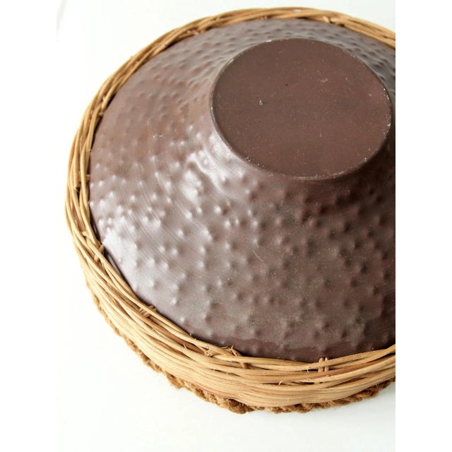 This vintage bowl features a hammered copper base paired with woven wicker sides and a braided rim, creating a striking...