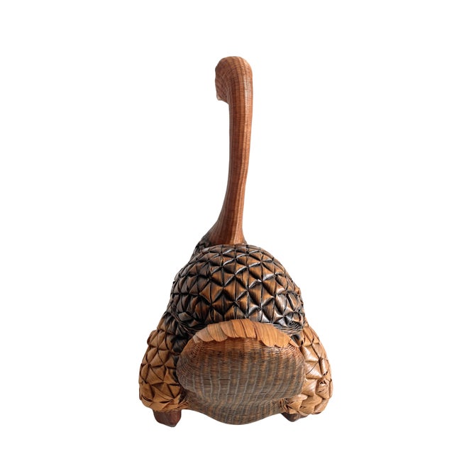 A vintage mid-century rattan goose basket box with a tall curved neck, carved beak, and removable back lid. The body is...