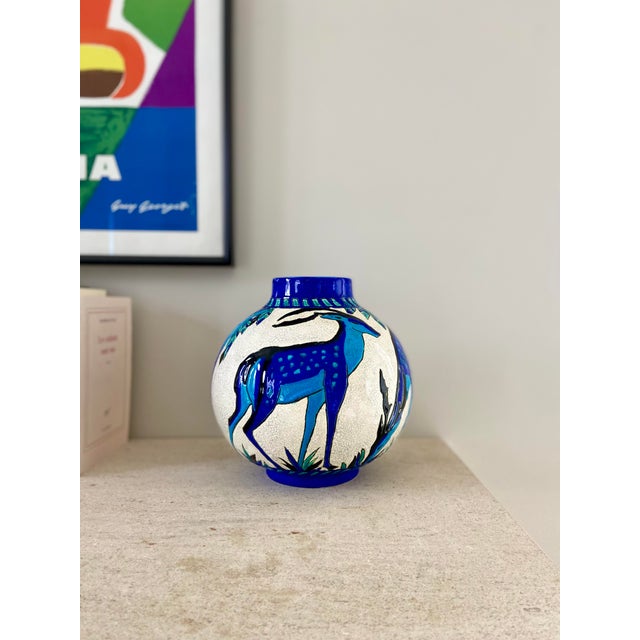 Earthenware ball vase decorated with deer, blue and turquoise enameled on a cracked background. Sealed and numbered under...