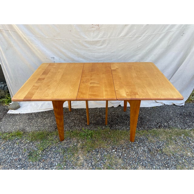Classic mid-century modern drop leaf dining table, model M166, by Heywood-Wakefield, crafted in solid maple with the...