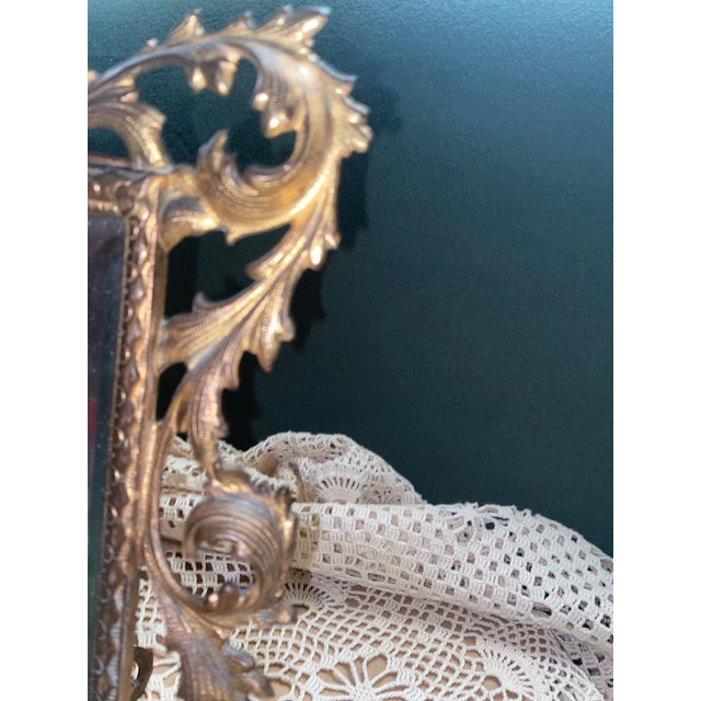 Ornate mirrors like this one have been popular decorative items for centuries, often used on vanities or dressing tables...
