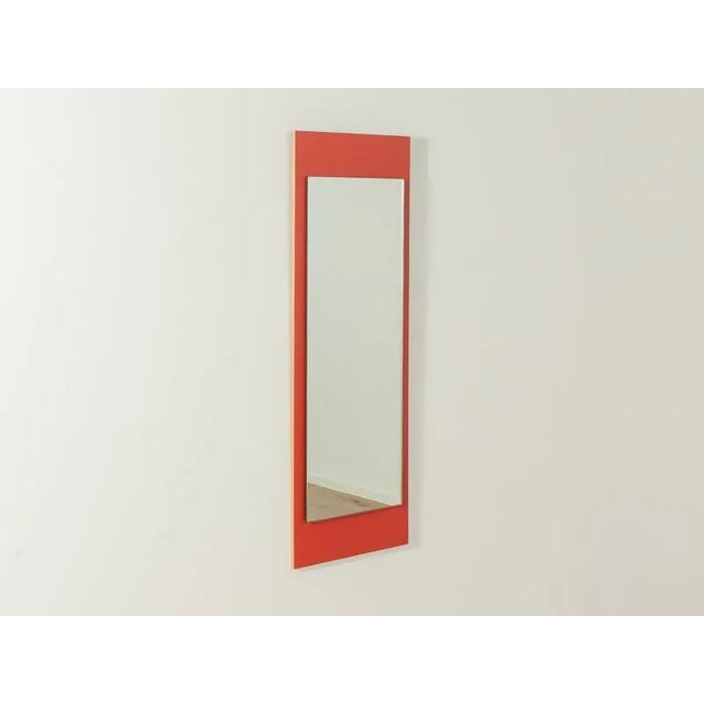 Unique mirror from the 1960s on a Formica-coated wooden panel in red. Made in Germany.