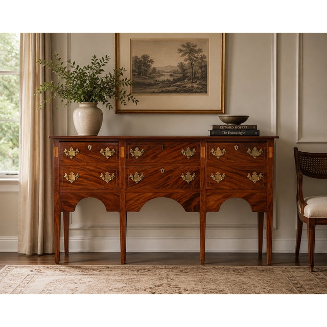 A refined early 20th century Federal Revival sideboard, showcasing beautifully figured flame mahogany veneers and elegant...