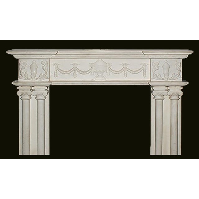 Georgian style marble fireplace mantel having paired colonette jambs with volute capitals and recessed decorated frieze...