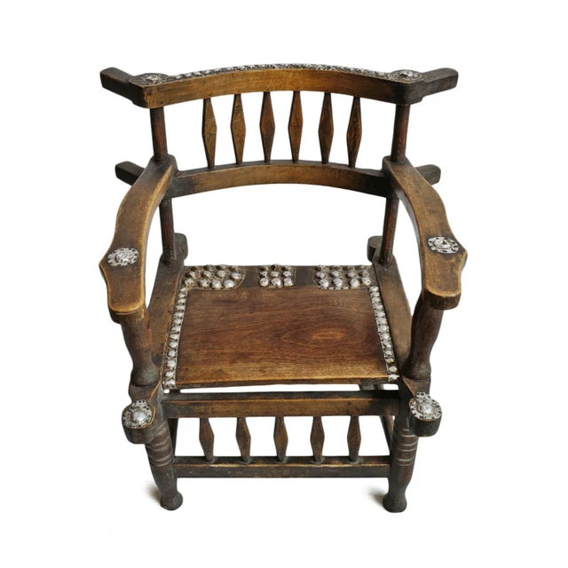 Vintage African ceremonial chief’s chair crafted from richly patinated hardwood with hand-carved spindle details,...