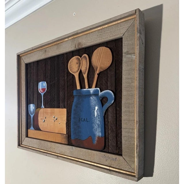 This folk art-style kitchen still life, lathe-art panel portrays cut-out painted wood elements affixed to a dark wood...