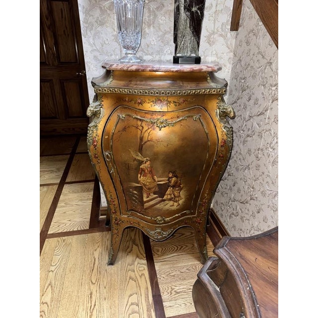 A Louis XV style bombe cabinet painted in the Vernis Martin manner. The swelling single door is painted with a charming...