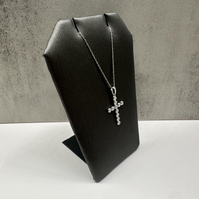 This elegant diamond cross necklace in 14kt white gold features 0.07 carats total weight of natural GH SI2–I1 round...