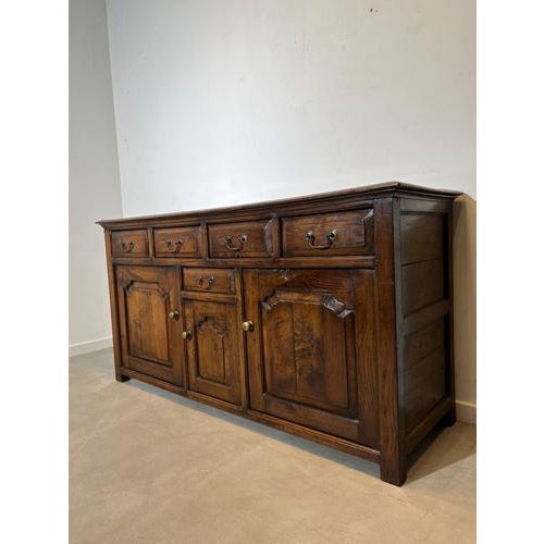 Beautiful large rustic sideboard in solid oak featuring hand-carved panel doors and warm aged patina. The cabinet has a...
