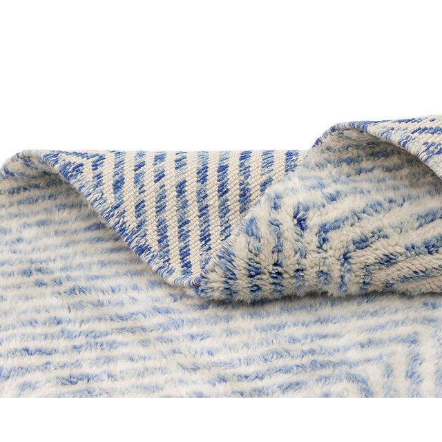 Elegant luxurious hand-knotted wool rug with a serene diamond pattern in Soft Azure and Ivory, offering a plush texture...