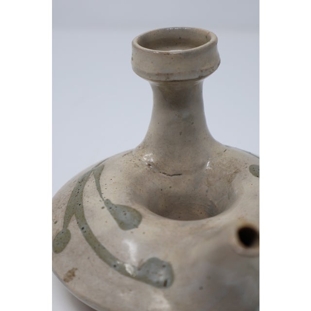 A distinctive pairing of decorative pottery, combining a signed Betty Selby Southwestern figural vessel with a Japanese...