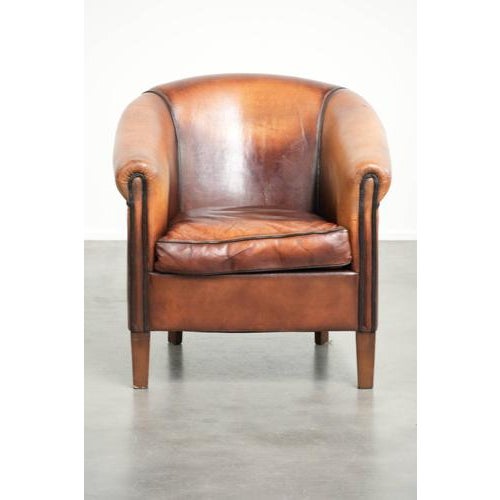 This vintage club armchair is made of sheepskin and features a beautiful color scheme. It is finished with black piping,...