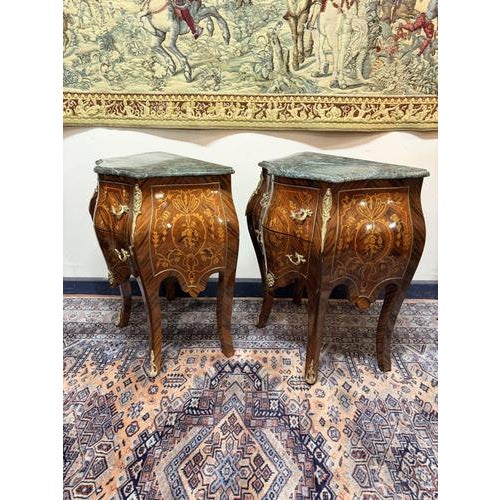 A striking pair of nightstands featuring beautiful marble tops paired with a refined veneer finish, offering a perfect...
